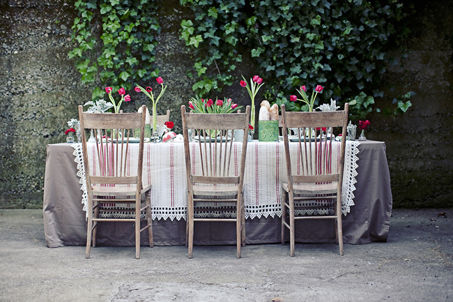 The tablescape included oak farmhouse chairs red tulips in simple glass 