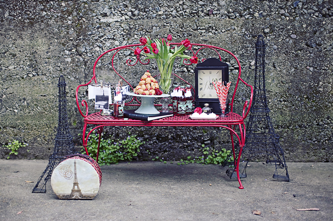 red bench with meringues, mini croquemboque, a clock, French postcards, and wire Eiffel Tower replicas