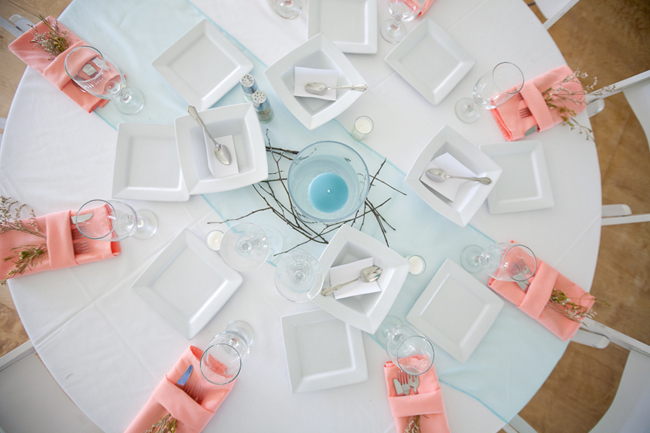 overhead shot of table setting with peach napkins, cutlery, and branches