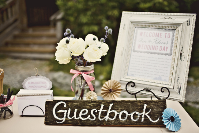 wood guestbook sign on table with framed welcome picture