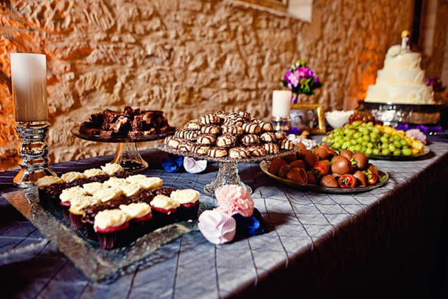 dessert table with clear vintage cake stands holding cupcakes, cake, and brownies