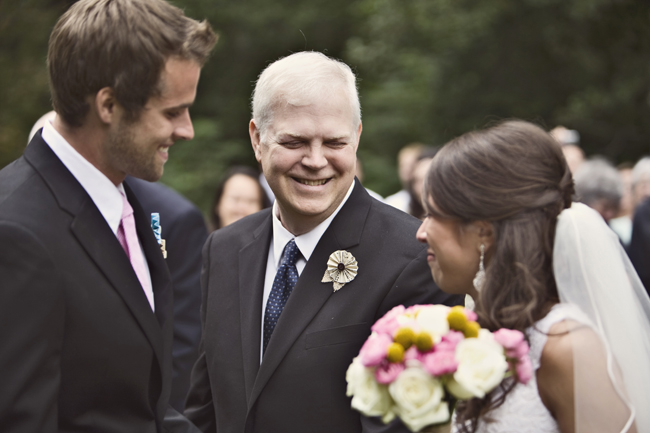 bride and groom with father at the alter