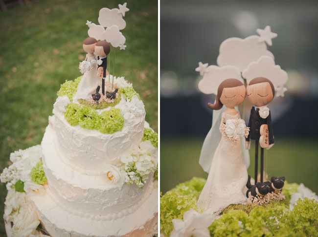 Custom wood cake topper of bride and groom with two dogs ontop 3-tier white wedding cake