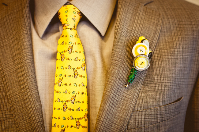 Groom with yellow button boutonniere and bright yellow tie with Ewok pattern