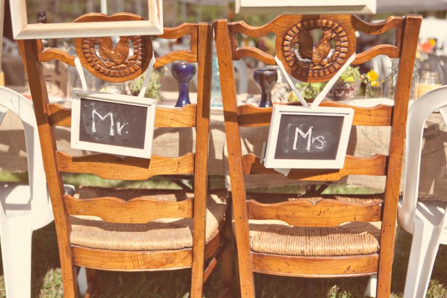 vintage chairs with a carved farm motif and chalkboard sign on back