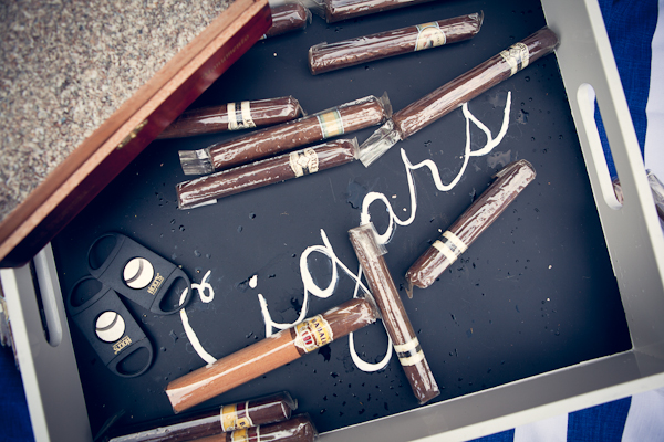 White tray with a chalkboard bottom  with "cigars" written in chalk and cigar wedding favors for guests in box