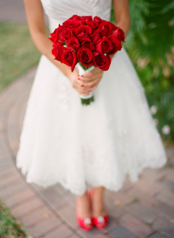 Brides wearing tea length wedding dress and red heels