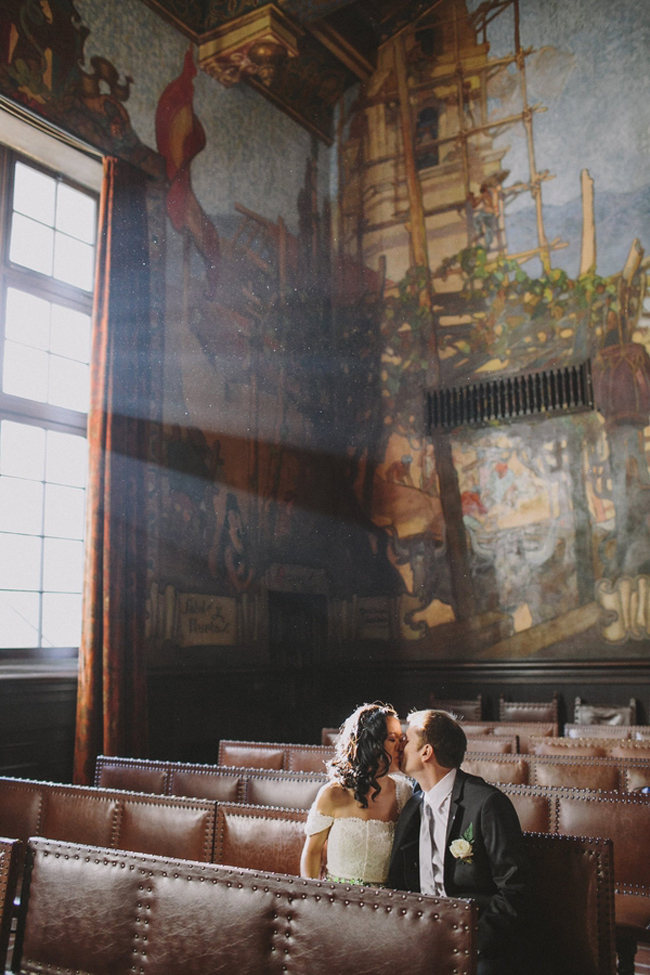 bride and groom kiss in the leather pew courthouse seats