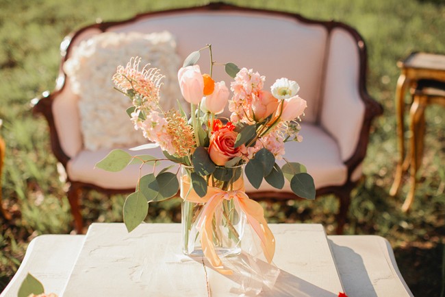 Centerpeice of peach flowers on marble slab table