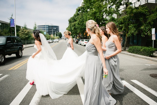 Bride and Bridesmaids in grey dresses walking across the street