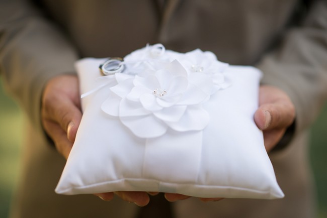 white ring pillow with white flower