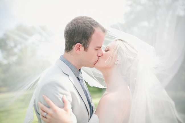 bride-and-groom-kissing-uv nder-wedding-veil