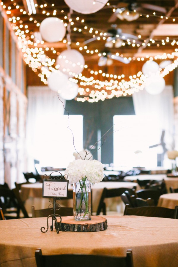 22 Lindsey Plantation in Greer SC wedding reception with white lanterns, white lights and a white and green floral arrangement on table with a reserved signs