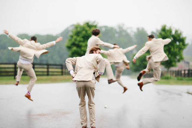 31 Groomsmen jumping in air and kicking heels in cream suits at Lindsey Plantation in Greer SC wedding