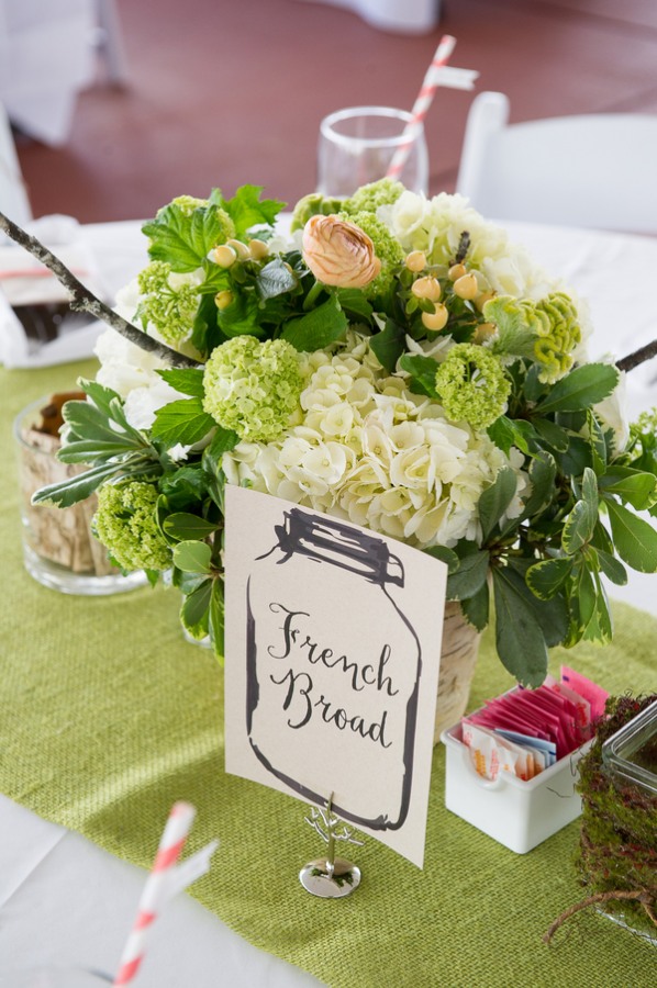 Centerpiece with hydrangeas, willow branches, moss, salmon ranunculas, succulents, peach hypericum berries, viburnum, and celosia