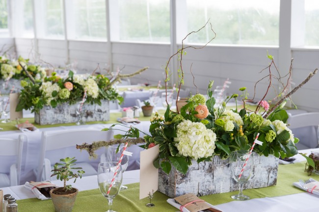 Centerpiece: hydrangeas, sprouted willow branches, moss, salmon ranunculas, succulents, peach hypericum berries, viburnum, and celosia