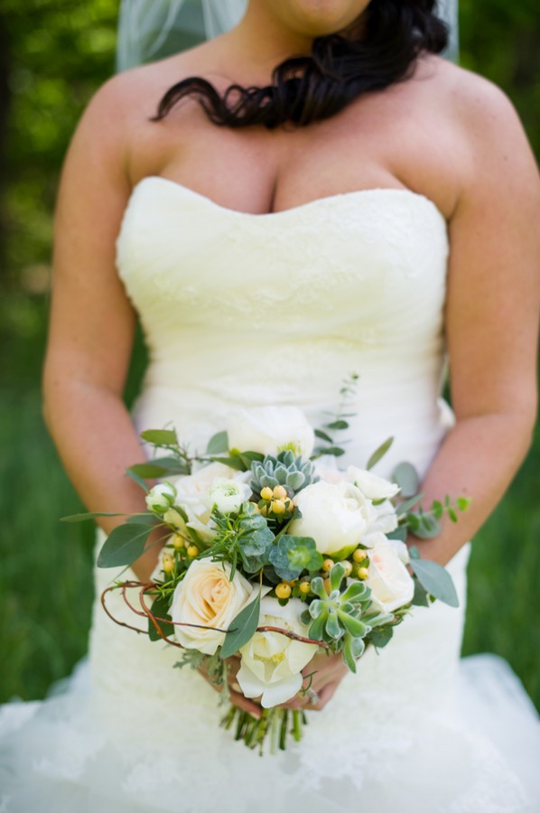 bride holding bouquet with white roses