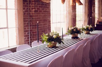 29 reception table with black and white strip table runner and black candles with gold flower vases