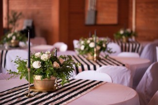 9 wedding reception tables with black and white striped table cloths gold flower vases and black candles