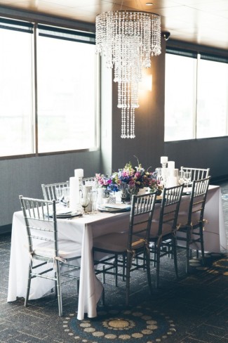 Silver and purple themed wedding reception table with silver chiavari chairs