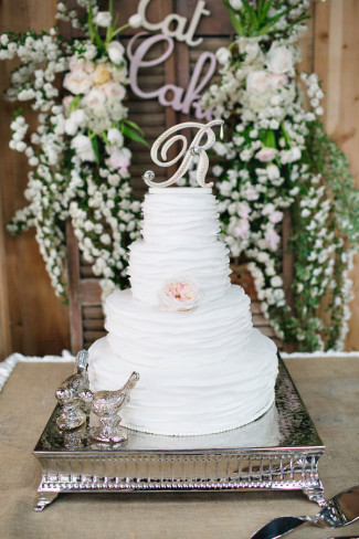 4-tier white wedding cake on square cake stand
