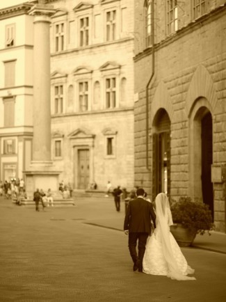 Black and white photo of bride and groom walking the streets of florence