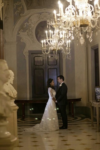 Bride and groom standing under chandaliere at the four season hotel in florence