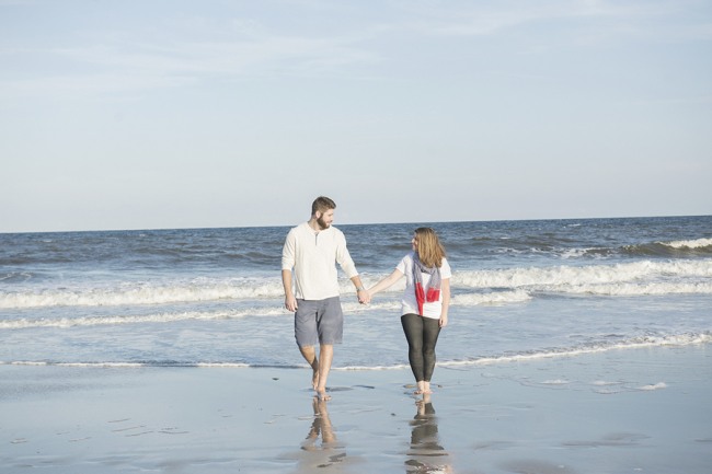 Couple-walking-on-beach-away-from-the-shoreline