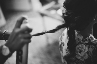 black and white photo of bride getting her hair sprayed with hairspray