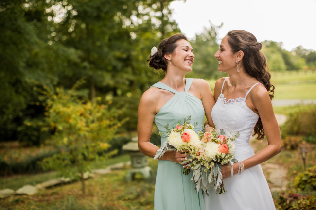bride and bridemaid smile at each other