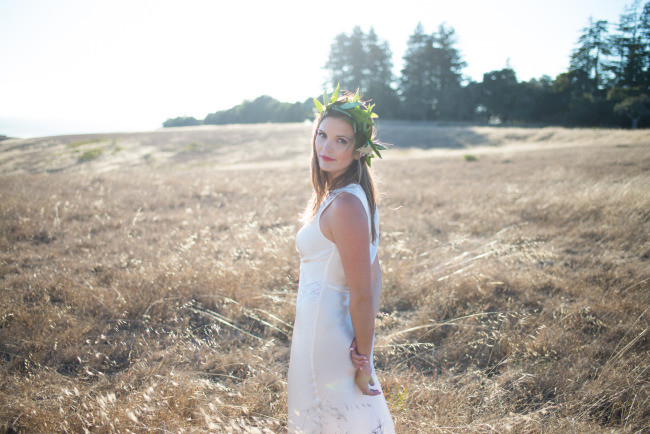model with wedding gown and flower crown in rustic field