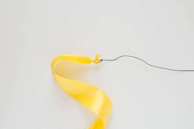 Floral wire wrapped around yellow ribbon 