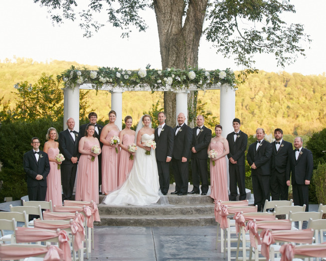 Bride and groom with bridal party standing on ceremony platform at Tate House Mansion 