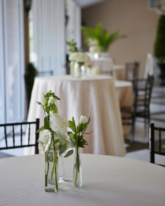 mismatched flower vases on cocktail table with white flowers
