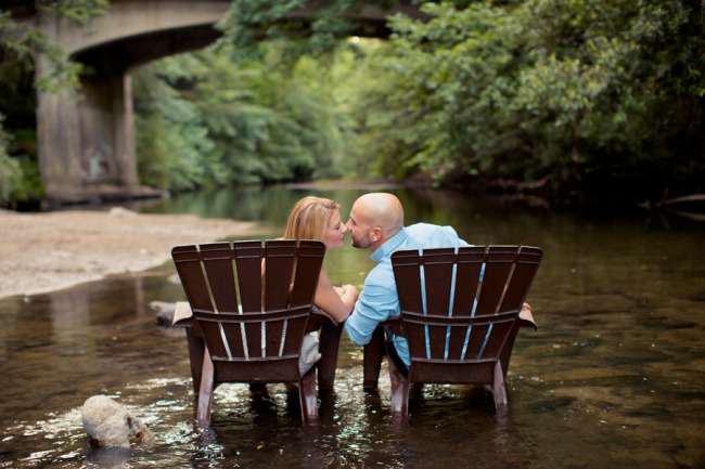 couple sitting on adirandak chairs in a river