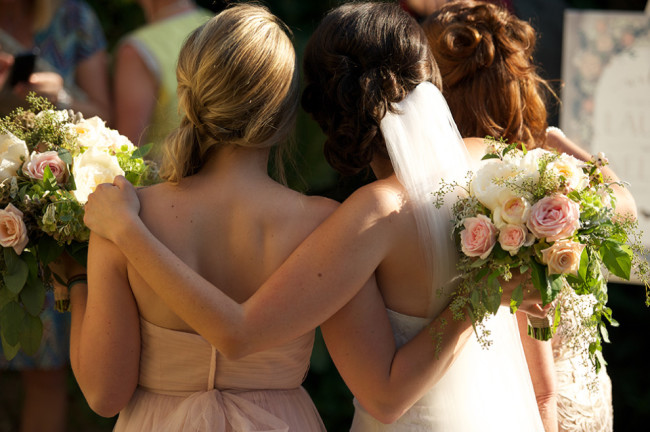 Bride standing with bridesmaids wearing blush pink gowns from BHLDN