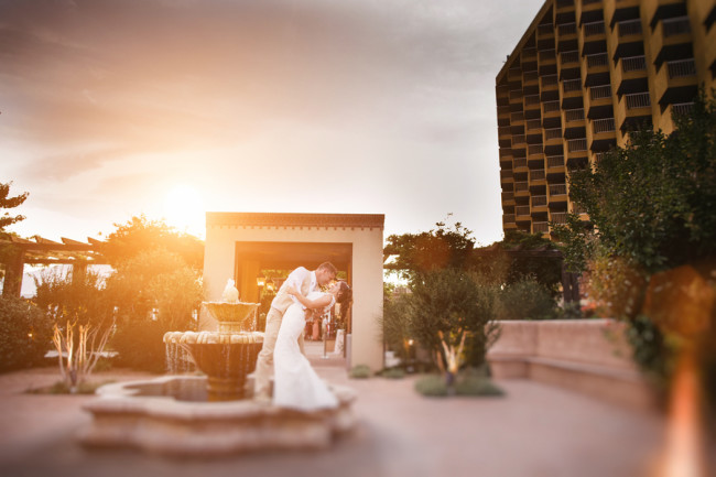 Bride and groom kissing on fountain of Hotel Albuquerque