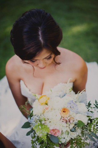 Bride carrying a bridal bouquet of blue hydrangeas, periwinkle thistle, white lisianthus, English garden roses, jasmine vine, seeded eucalyptus , dusty miller and ranunculas.