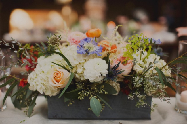 Wedding reception floral center pieces with hydrangeas, thistle, lisianthus, roses, jasmine vine, seeded euc, dusty miller and ranunculas."