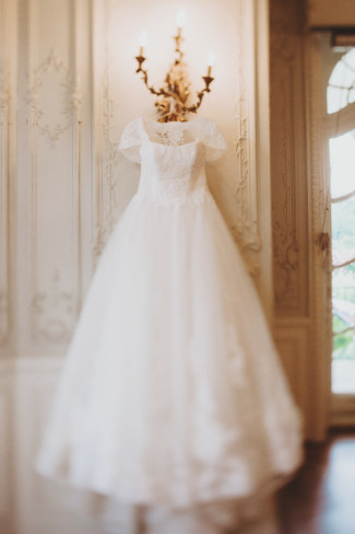 Sottero & Midgley gown hanging from a wall sconce