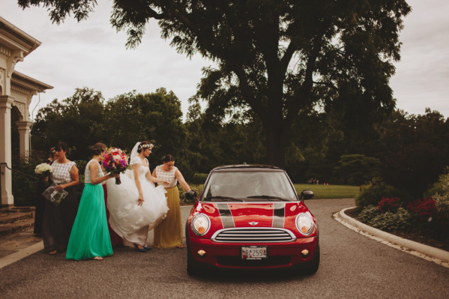 Bridesmaids in all different pantone colors helping bride to mini car
