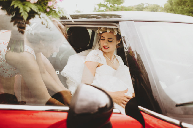 Bride getting into a red mini