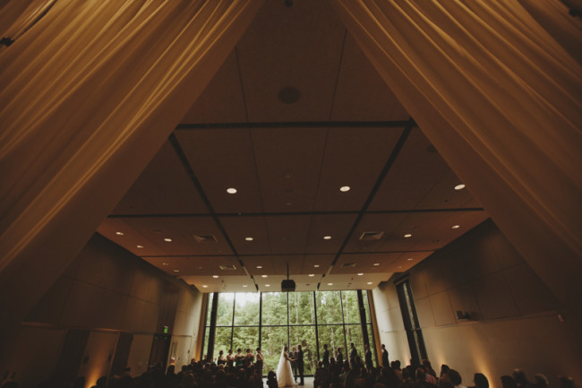 Bride and groom getting married in front of a big window