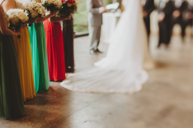 Wedding ceremony with bridesmaids lined up wearing pantone colors