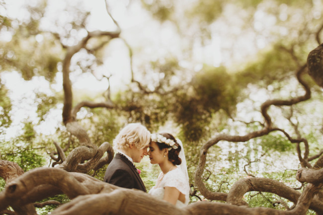 Bride and groom head to head surrounded by tree branches