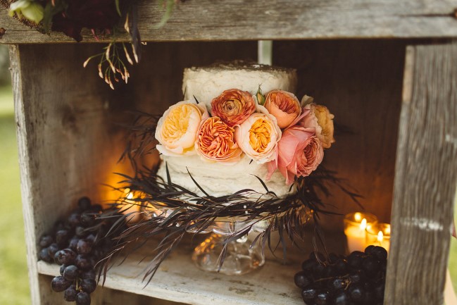 styled shoot cake with flowers and candles on wood bookshelf