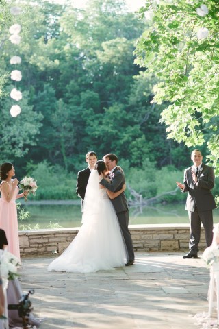 Bride and groom kissing during wedding ceremony at Darby House in Ohio 