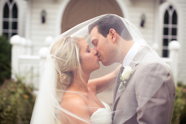 bride and groom kiss under veil