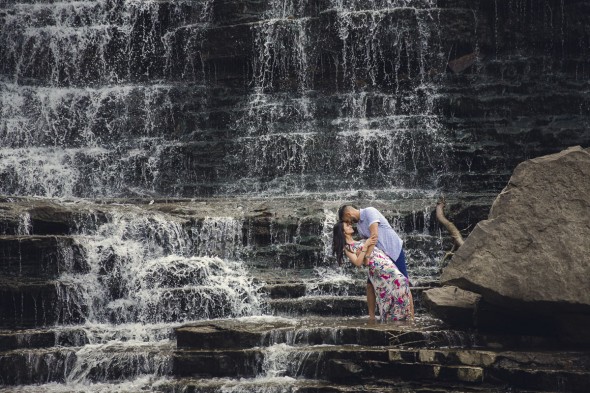 couple on rock ledge with waterfall