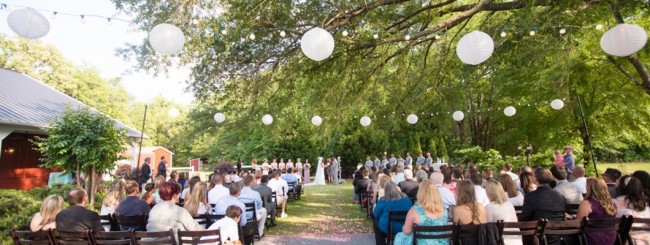 Outdoor wedding ceremony with white lanterns overhead